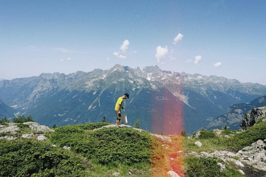 Hiker on mountain ridge with lens flare