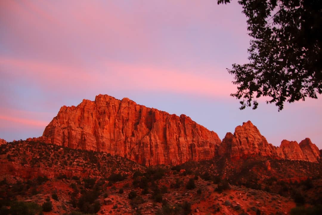 A mountain range with a pink sky in the background
