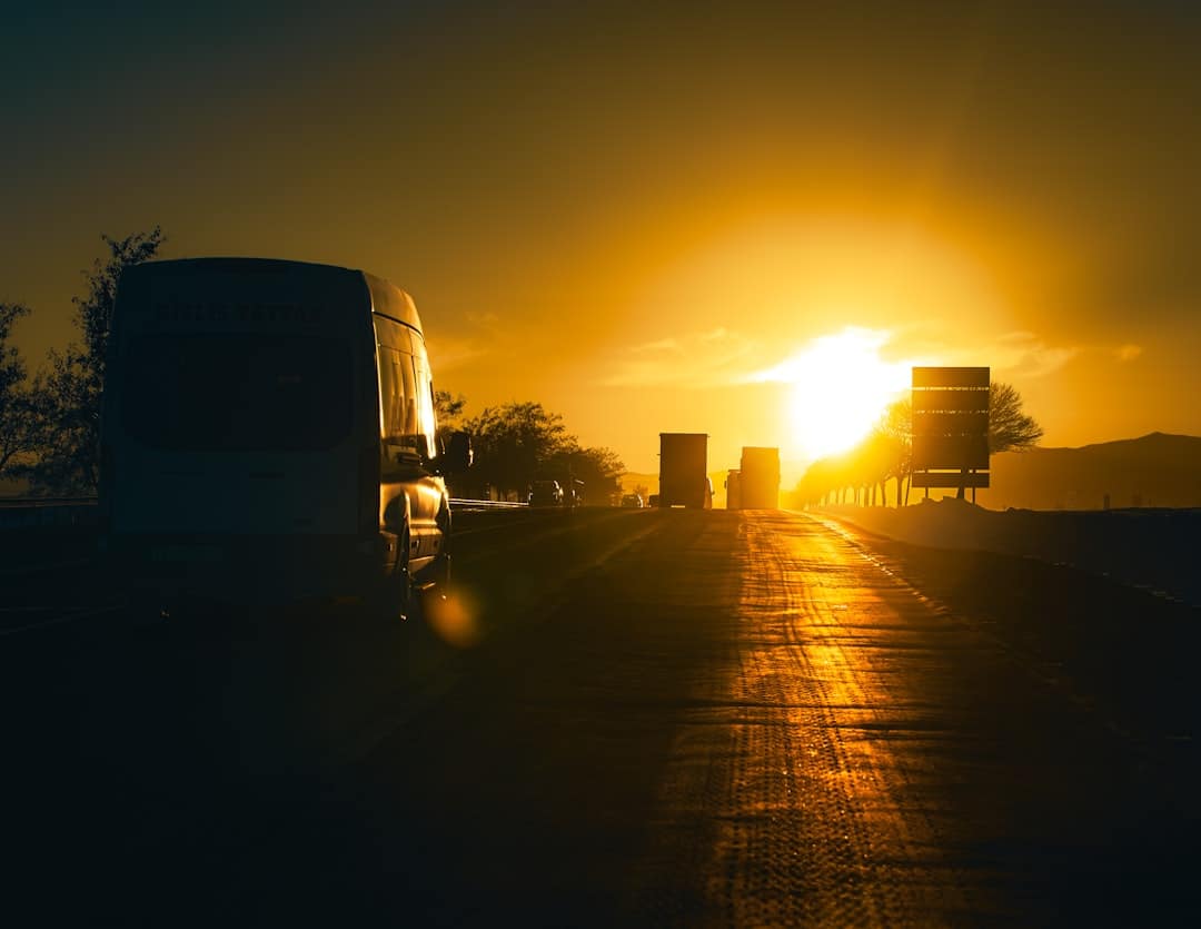 Cars driving on a road at sunset