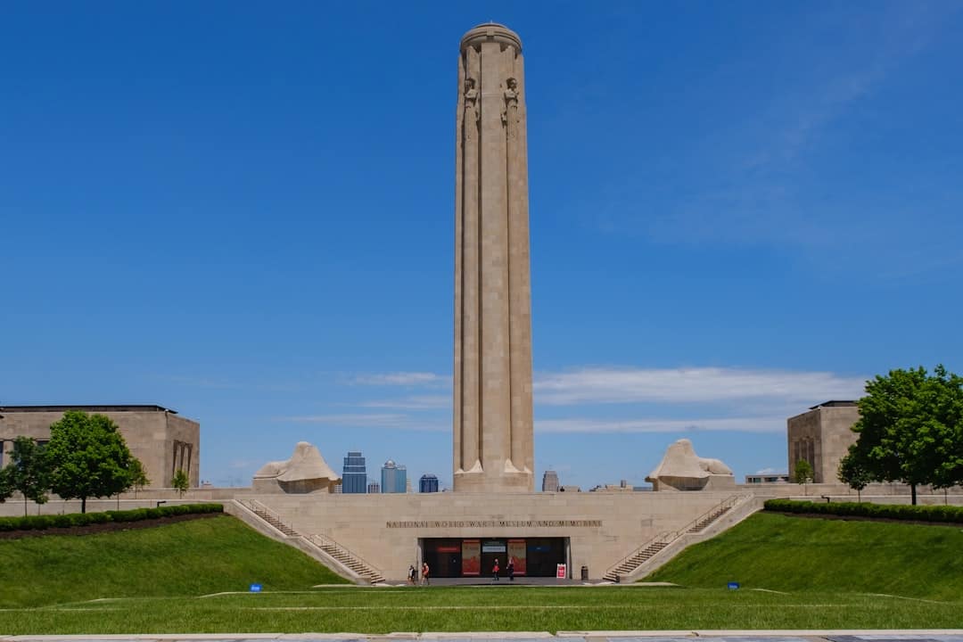 a tall monument in a park with Liberty Memorial in the background